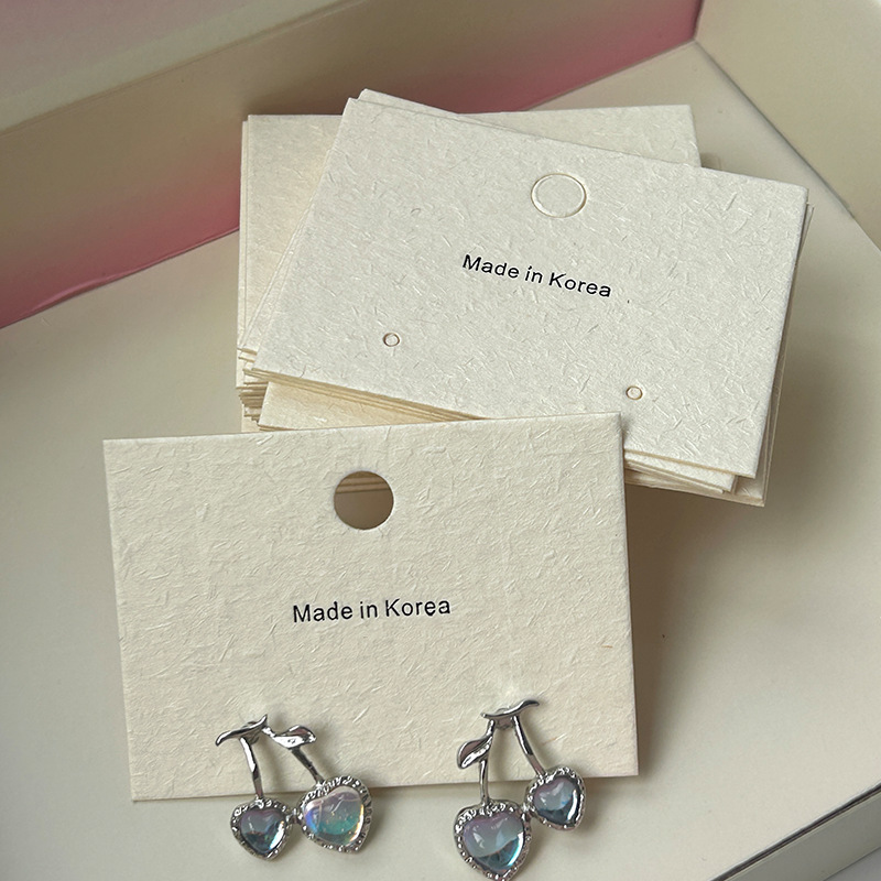 Personalized jewelry display cards featuring a gold foil stamped company logo and branding.